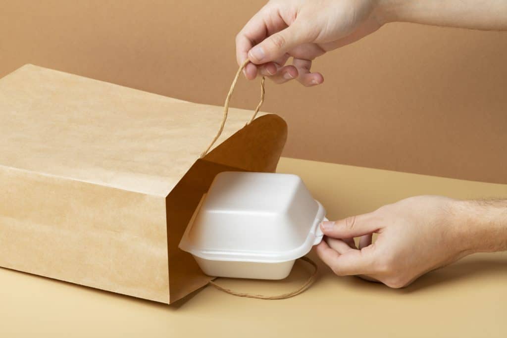 close up hand holding food container