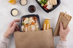 close up hands holding food pack and cutlery