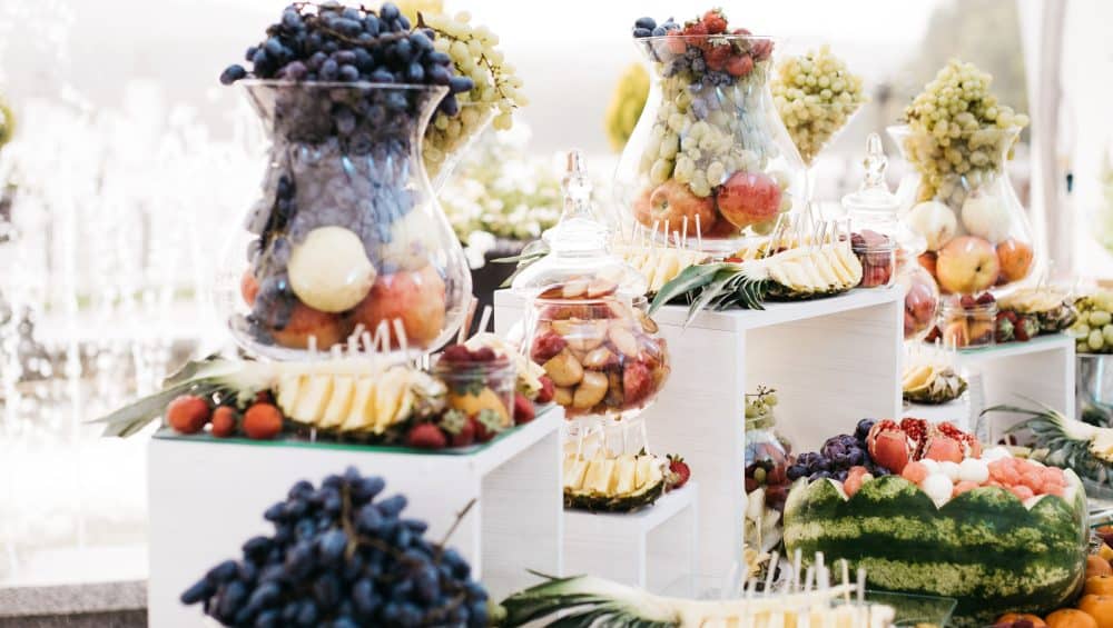 glass vase with grape stand dinner table with fruits